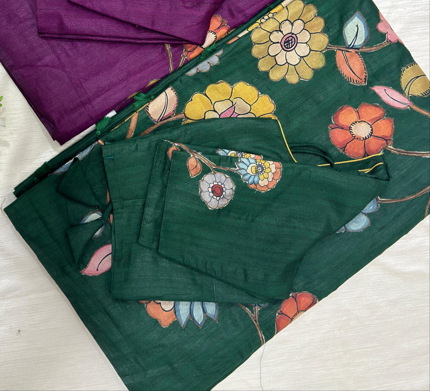 Purple and green sarees with floral patterns on a white background